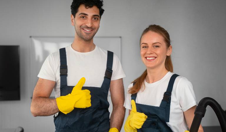 Man and a woman in uniform showing thumps up and smiling