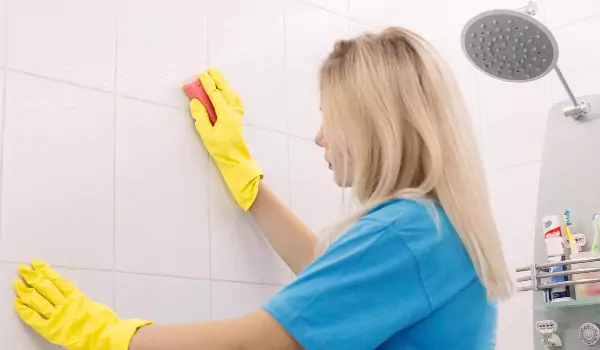 young woman cleaning up a bathroom surface