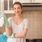 woman with a cleaning spray inside of a kitchen