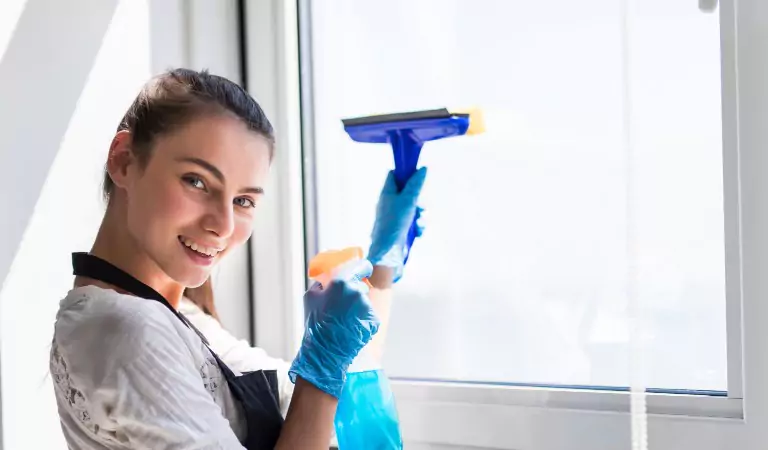 woman cleaning up window glass with a wiper