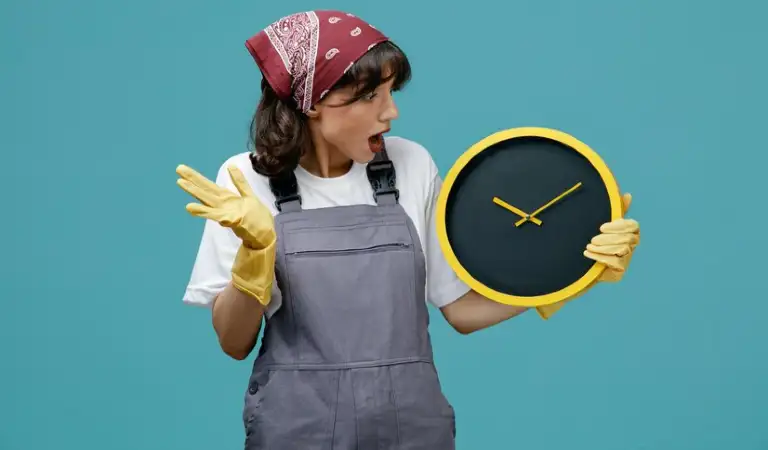 A lady in uniform and yellow gloves holding a watch in her hand.