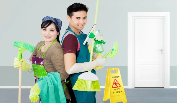 Young man and a woman holding cleaning cleaning supplies