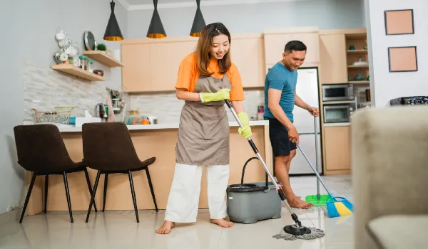 Happy asian couple cleaning their dinning room together