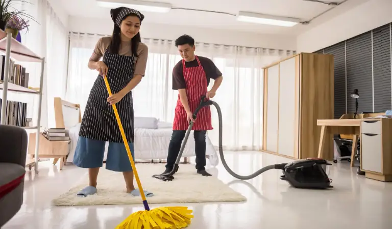 Young couple using vacuum cleaner and mop to clean home bedroom hygiene and health