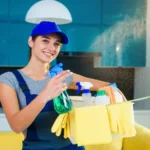 Young female professional cleaner in special uniform at apartment.