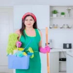 Portrait of woman carrying cleaning equipments