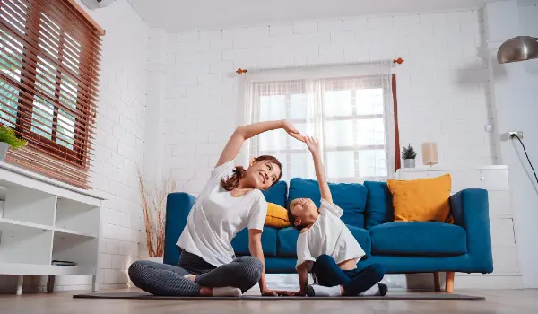 Mother and daughter exercising together happily at home for flexibility happy family together at clean home concept